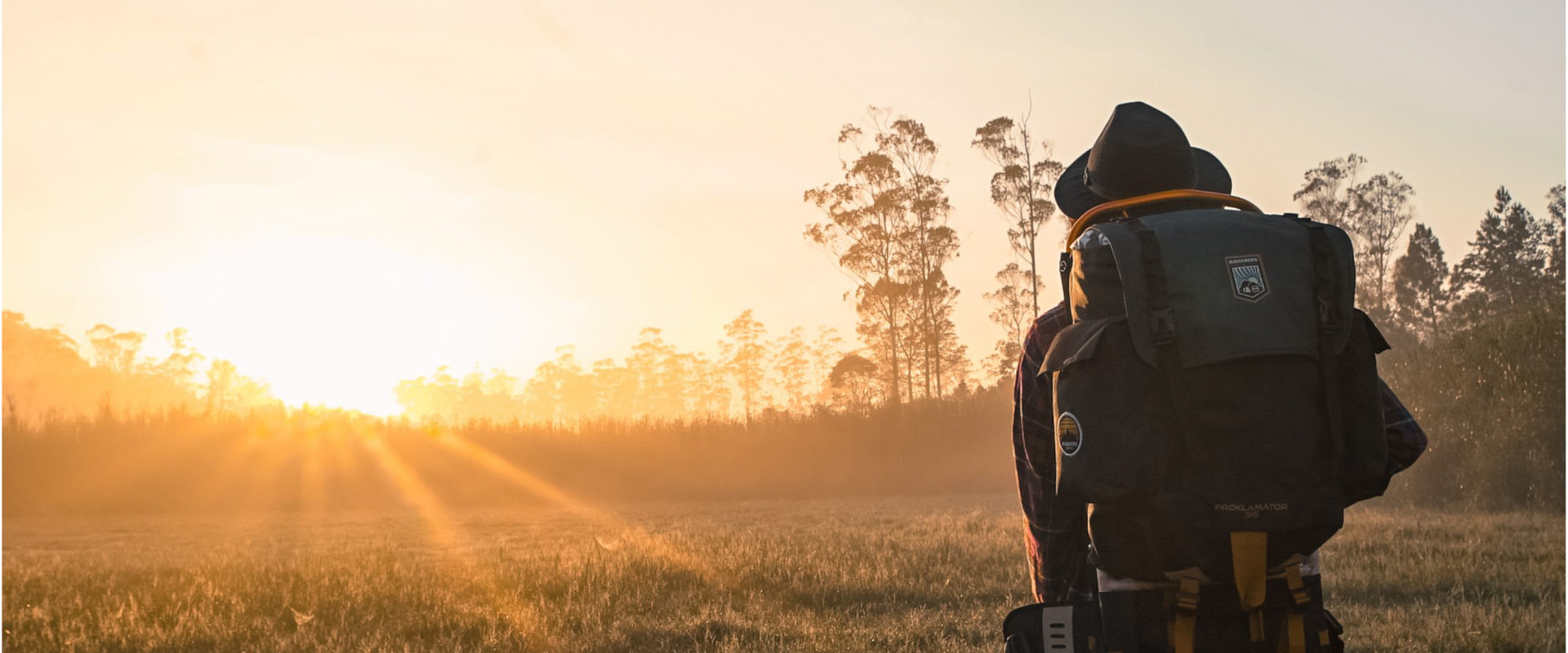 Hiker looking at rising sun